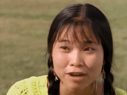 a close up of a woman 's face with pigtails and a yellow shirt