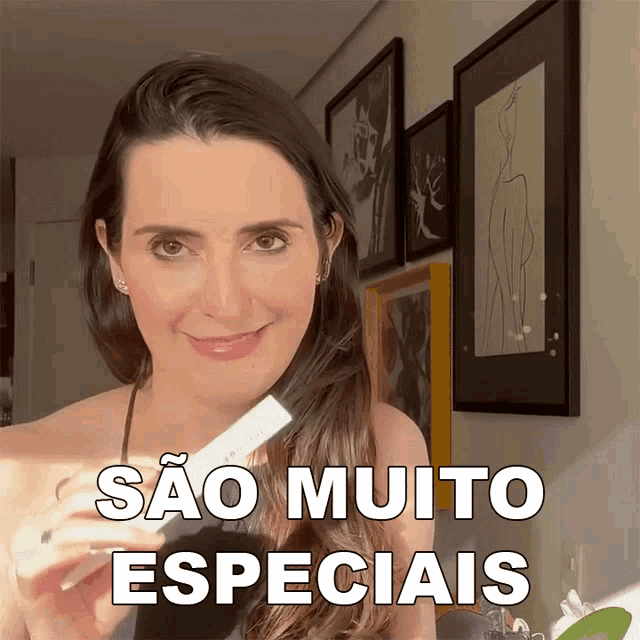 a woman is smiling and holding a bottle with sao muito especiais written above her