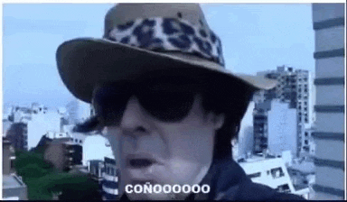 a man wearing a cowboy hat and sunglasses is making a funny face .