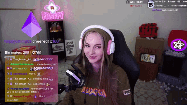 a woman wearing headphones is sitting in front of a screen that says fasffy on it