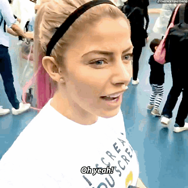 a woman wearing a white shirt that says oh yeah on it