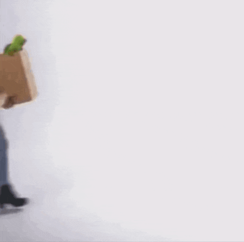 a woman in a hat is holding a cardboard box full of vegetables