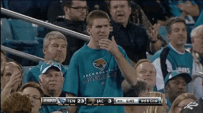 a man in a jacksonville jaguars shirt stands in a crowd