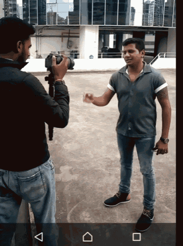 a man is taking a picture of another man with his camera