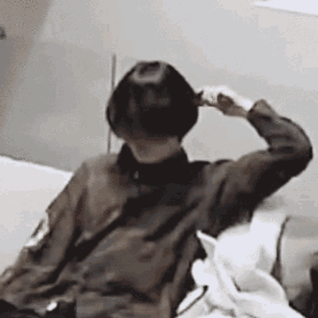 a person is sitting on a couch holding their hair in their hand .