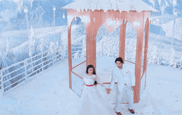 a man in a white suit and a woman in a white dress are dancing