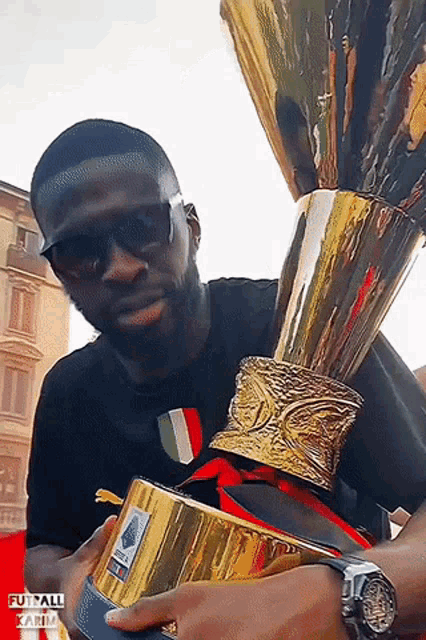 a man holding a trophy with the word futsal on the bottom right