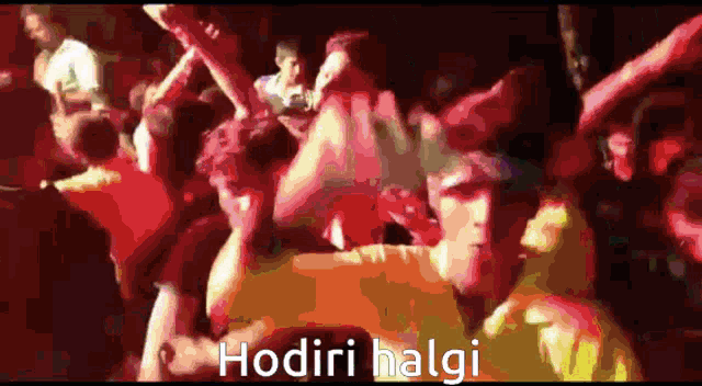 a crowd of people are dancing in a dark room and the words hodiri halgi are visible