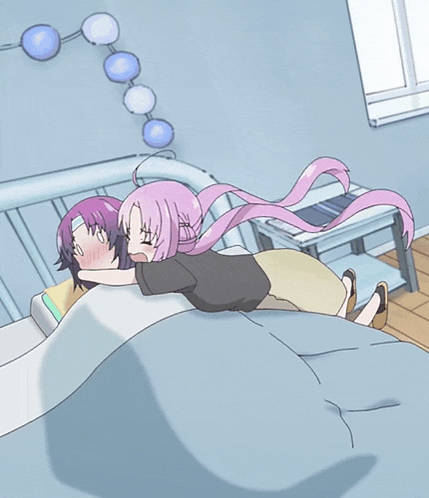 a girl with pink hair is hugging another girl in a bed