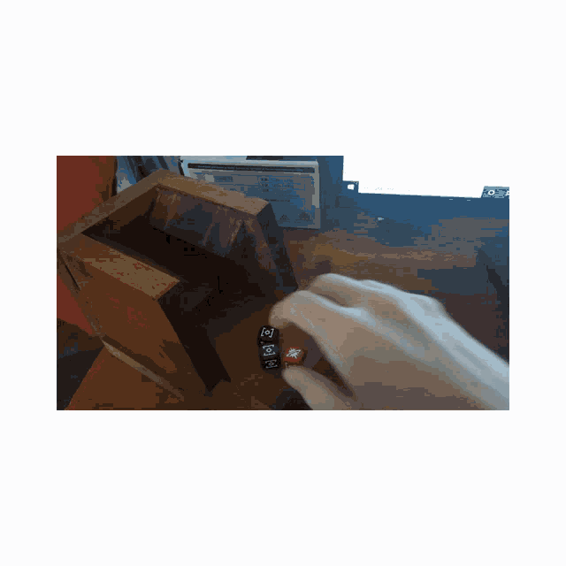 a person 's hand is reaching into a wooden box with the letter n visible