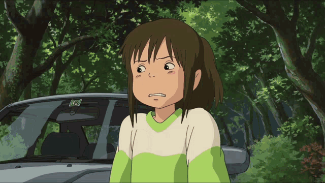 a girl in a green and white sweater stands next to a car