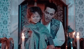 a man is holding a little girl in his arms while sitting in a chair .