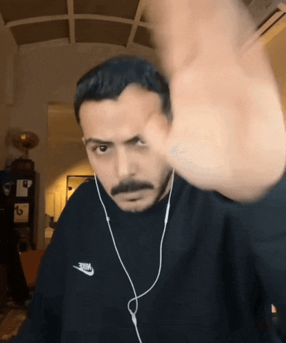 a man wearing ear buds and a black nike sweatshirt