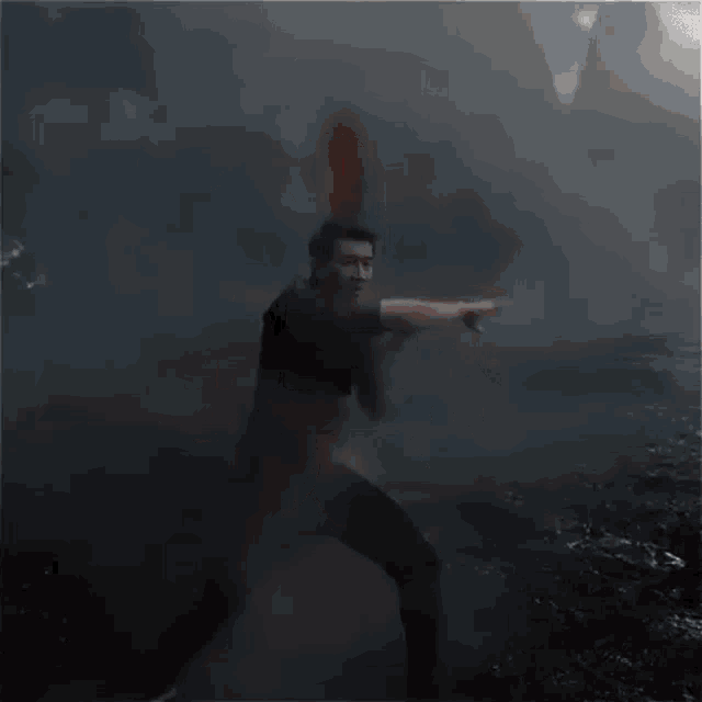 a man is holding a sword in his hand in the dark .