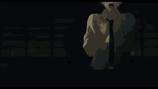a man in a suit and tie is standing in the dark with his mouth open and a ghost in the background .