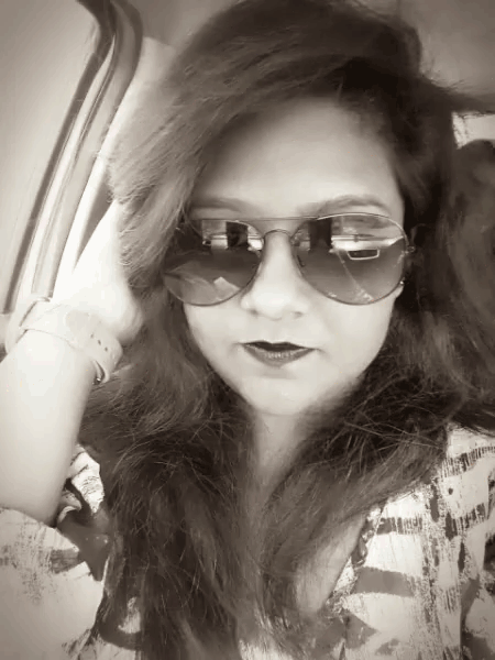 a woman wearing sunglasses looks at the camera