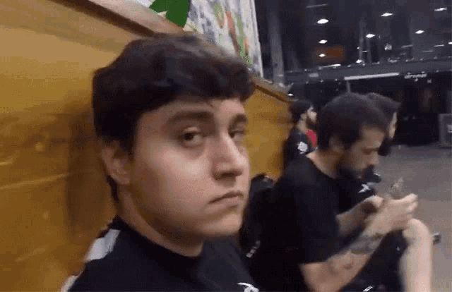 a man in a black shirt is sitting next to another man in a black shirt .