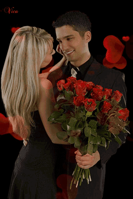 a man is holding a bouquet of red roses and a woman is touching his cheek