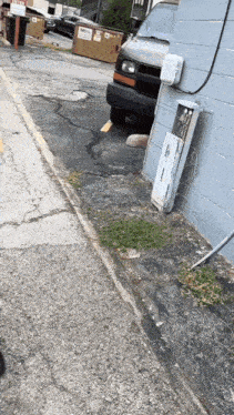 a white van is parked on the side of the road next to a brick wall with a sign that says no parking