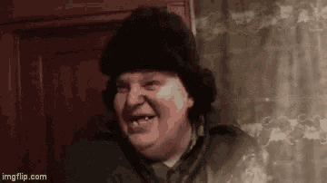 a man wearing a fur hat is smiling .