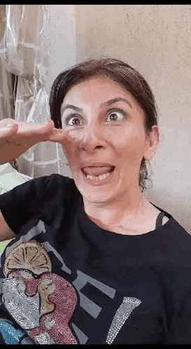 a woman in a black shirt is making a funny face with her tongue hanging out .