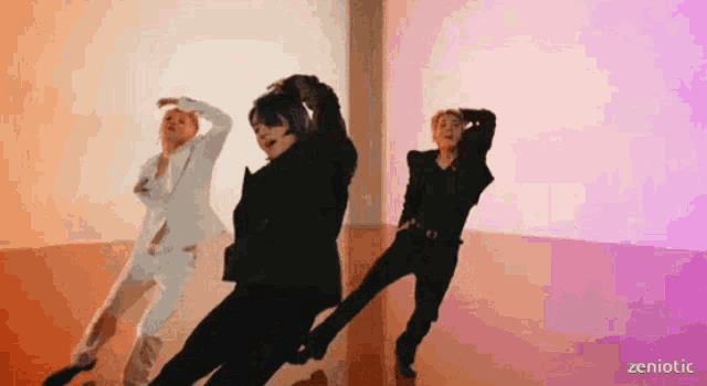 a group of people are dancing in a room with a purple wall behind them .