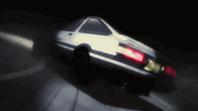 a car is driving down a road at night with the lights on