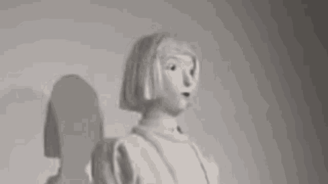 a blurry picture of a person standing in front of a wall holding their head .