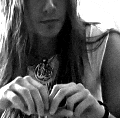 a black and white photo of a woman wearing a necklace that says w on it