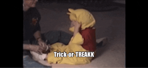 a child in a winnie the pooh costume says trick-or-treatk while sitting on the ground .