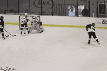 a hockey game is being played in front of a mva advertisement
