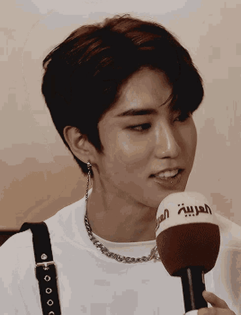 a young man is talking into a microphone that says arabia on it