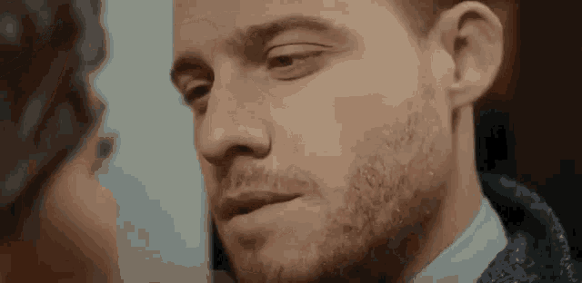a close up of a man 's face with a woman 's face behind him .