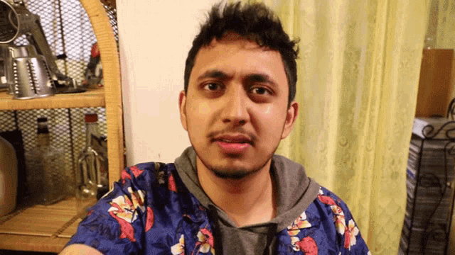 a man in a blue shirt with flowers on it