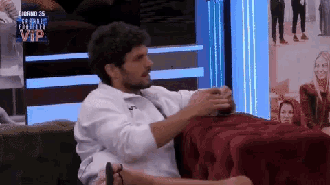 a man is sitting on a red couch with a sign that says giorno 35 vip