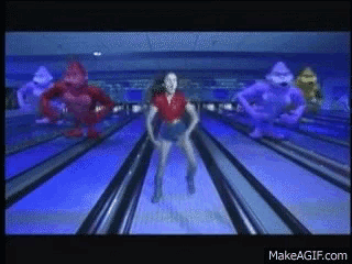 a woman is dancing in a bowling alley with purple monsters