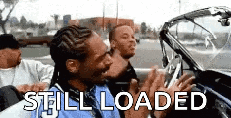 snoop dogg is driving a convertible car with two other men .