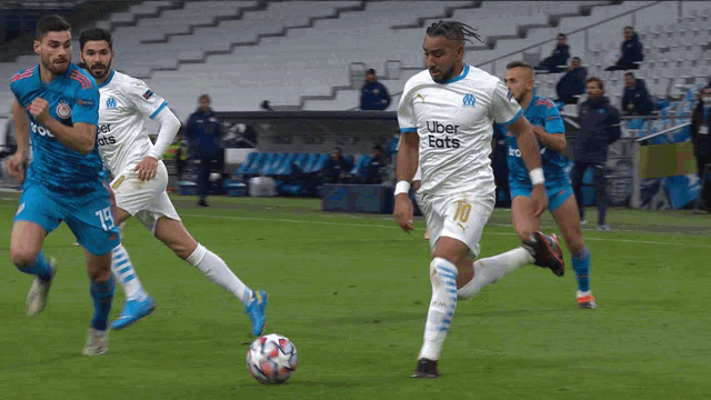 a soccer player wearing an uber eats shirt kicks the ball