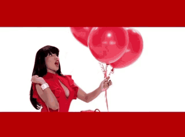 a woman in a red dress blowing up red balloons