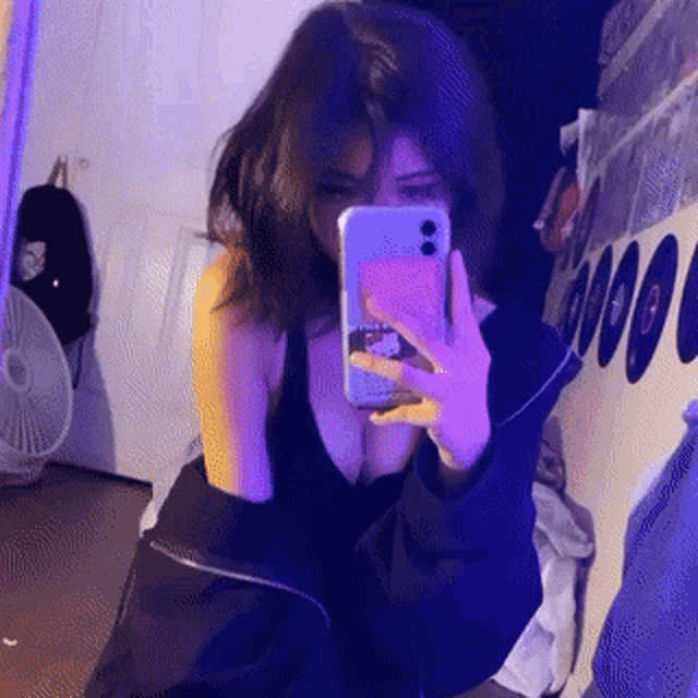 a girl is taking a picture of herself in a mirror with her phone