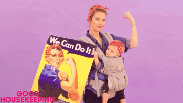 a woman is holding a baby in a carrier and a sign that says `` we can do it '' .
