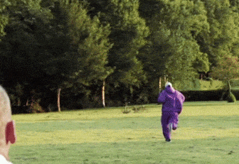 a person in a purple jumpsuit is running in a field
