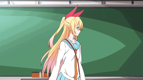 a girl with blonde hair and red ears stands in front of a green chalkboard