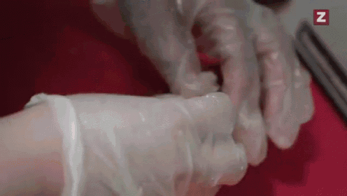 a close up of a person 's hands wearing gloves with the letter z in the corner .