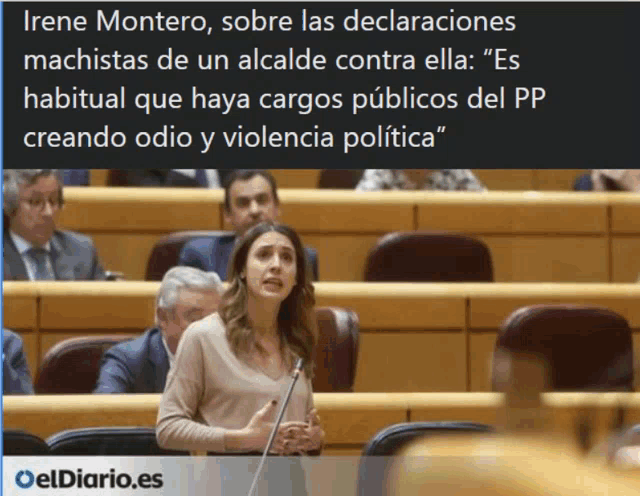 a woman stands in front of a microphone in a spanish parliament chamber