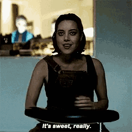 a woman sitting on a bar stool says " it 's sweet really "
