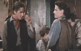 a group of men are standing next to each other in a room and talking to each other .
