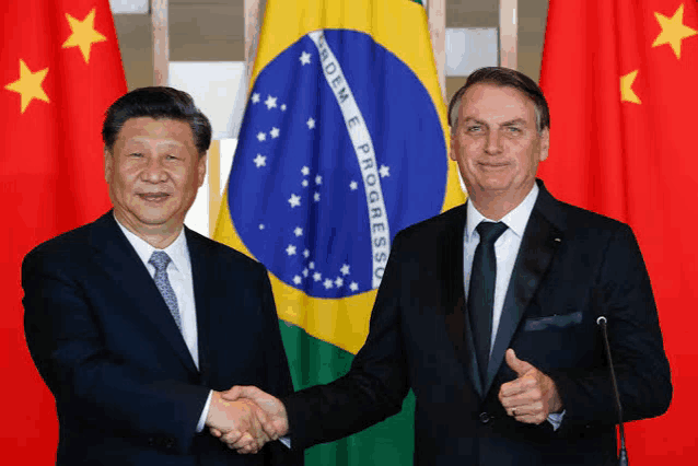 two men shaking hands in front of a flag that says proem e progresso