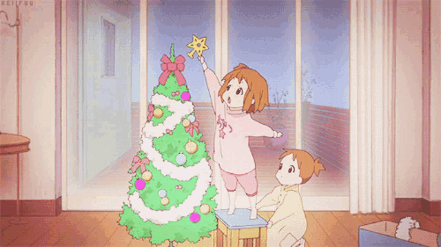 two little girls decorate a christmas tree with a yellow star on top