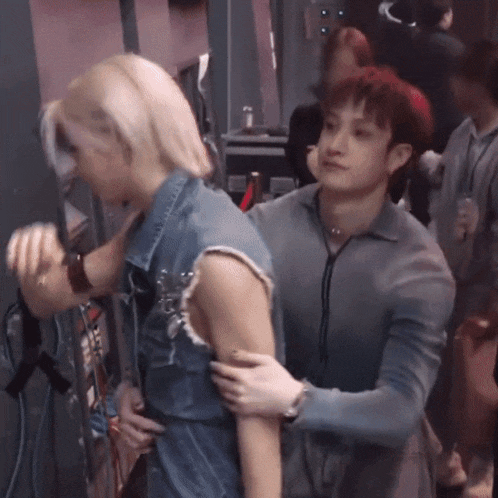 a man is hugging a woman in a crowd of people
